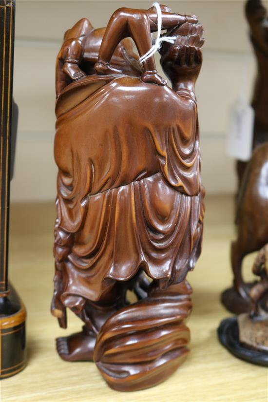 Three Chinese figural wood carvings and a soapstone carving of a child riding a water buffalo,